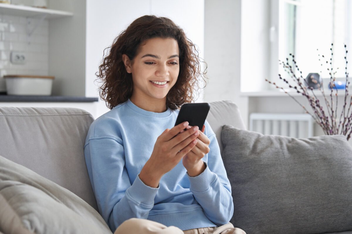 girl holding cell phone using smartphone device at home